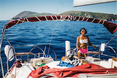 simsearch:614-09078703,k - Woman in bikini steering boat Stockbilder - Premium RF Lizenzfrei, Bildnummer: 614-09078711