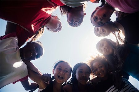 Low angle view of schoolgirl soccer team huddled in circle Photographie de stock - Premium Libres de Droits, Code: 614-09078968