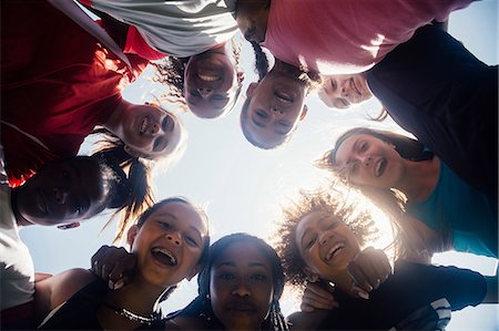 Low angle view of schoolgirl soccer team huddled in circle Stock Photo - Premium Royalty-Free, Code: 614-09078970