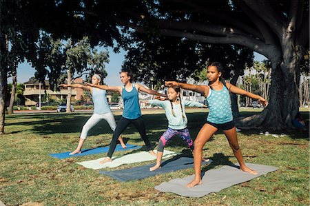 flexible - Schoolgirls practicing yoga warrior two pose on school sports field Foto de stock - Sin royalties Premium, Código: 614-09078982