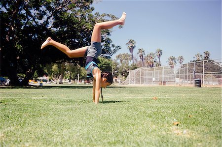 flexible preteen - Schoolgirl doing cartwheel on school sports field Stock Photo - Premium Royalty-Free, Code: 614-09079043