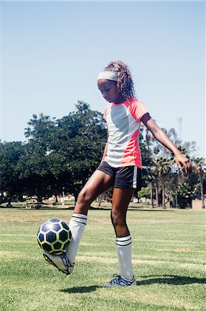 school sports - Teenage schoolgirl practicing keepy uppy with soccer ball on school sports field Stock Photo - Premium Royalty-Free, Code: 614-09079058