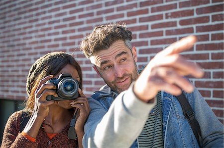 Man and woman outdoors, man pointing ahead, woman looking through camera Stock Photo - Premium Royalty-Free, Code: 614-09079129