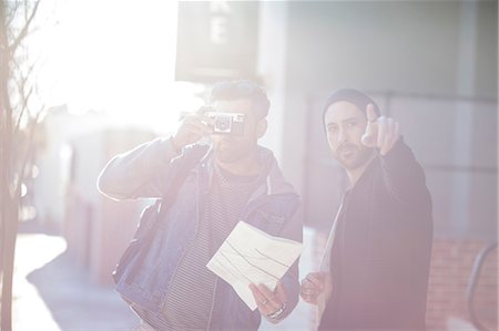 simsearch:614-09079138,k - Two men in street, mid adult man looking through camera, young man pointing ahead Foto de stock - Sin royalties Premium, Código: 614-09079122