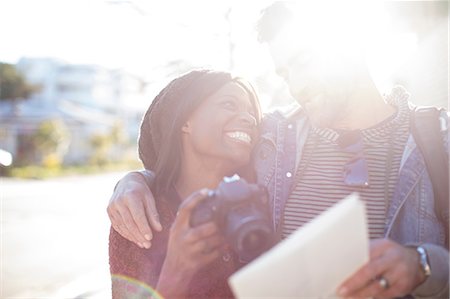 person holding a camera - Man and woman outdoors, woman holding camera, smiling Stock Photo - Premium Royalty-Free, Code: 614-09079138