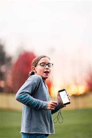 simsearch:614-07652557,k - Girl listening to smartphone earphone music dancing in garden Stock Photo - Premium Royalty-Free, Code: 614-09079155