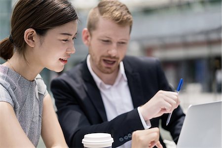 simsearch:649-08924437,k - Young businesswoman and man looking at laptop at sidewalk cafe Stock Photo - Premium Royalty-Free, Code: 614-09110701