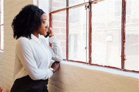 Woman in industrial office building making telephone call on smartphone Stock Photo - Premium Royalty-Free, Code: 614-09110840