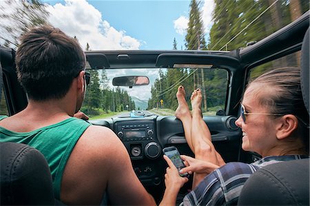 Young woman with smartphone driving on road trip with boyfriend, Breckenridge, Colorado, USA Stock Photo - Premium Royalty-Free, Code: 614-09110913