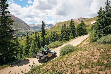 enroute - Road trip couple looking out at Rocky Mountains from four wheel convertible, Breckenridge, Colorado, USA Stock Photo - Premium Royalty-Free, Code: 614-09110920