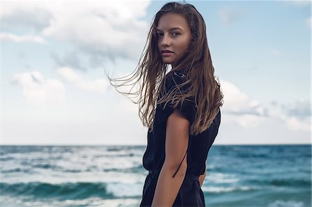 Portrait of young woman looking over her shoulder on beach, Odessa, Odessa Oblast, Ukraine Foto de stock - Sin royalties Premium, Código: 614-09110986