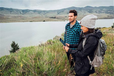 Couple hiking, standing beside Dillon Reservoir, young woman holding digital tablet, Silverthorne, Colorado, USA Foto de stock - Sin royalties Premium, Código: 614-09127199