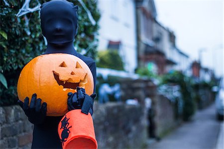 Portrait of boy in halloween costume, holding pumpkin and trick or treat bucket Stock Photo - Premium Royalty-Free, Code: 614-09127264