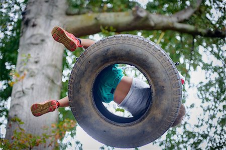 people wearing tennis shoes - Low angle view of boy playing on tyre swing in garden Stock Photo - Premium Royalty-Free, Code: 614-09127274