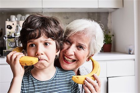 picture of frowning grandmother - Grandmother and grandson fooling around, using bananas as telephones, laughing Stock Photo - Premium Royalty-Free, Code: 614-09127396
