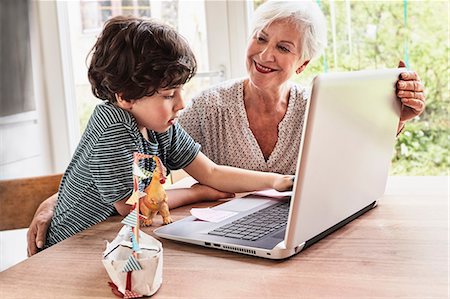simsearch:614-09127363,k - Grandmother and grandson sitting at table, using laptop Stock Photo - Premium Royalty-Free, Code: 614-09127400