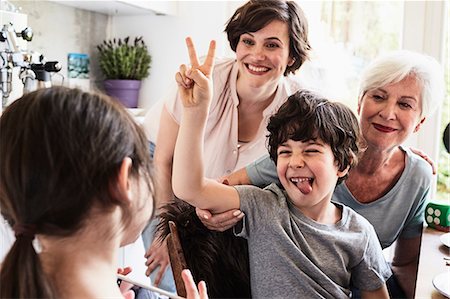 simsearch:640-08089329,k - Young girl photographing, brother, mother and grandmother, using smartphone Stock Photo - Premium Royalty-Free, Code: 614-09127417