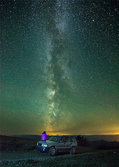 Person sitting on car, looking at view of milky way, rear view, Nickel Plate Provincial Park, Penticton, British Columbia, Canada Stock Photo - Premium Royalty-Free, Image code: 614-09127435
