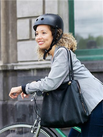 simsearch:614-06536783,k - Mid adult woman sitting on bicycle, wearing safety helmet Fotografie stock - Premium Royalty-Free, Codice: 614-09135021