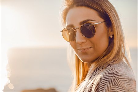 simsearch:614-09135032,k - Portrait of woman wearing sunglasses looking at camera smiling Photographie de stock - Premium Libres de Droits, Code: 614-09147689