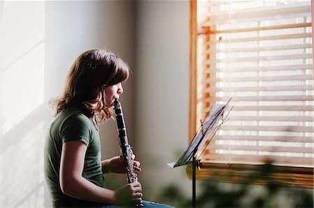 Girl at clarinet practice by window Stock Photo - Premium Royalty-Free, Code: 614-09147695