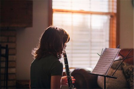 Girl at clarinet practice by window Stock Photo - Premium Royalty-Free, Code: 614-09147697