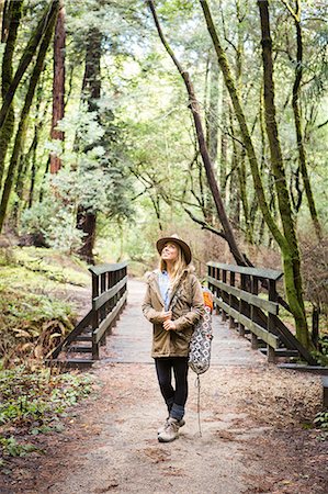 Young woman near forest footbridge looking up Stock Photo - Premium Royalty-Free, Code: 614-09147704