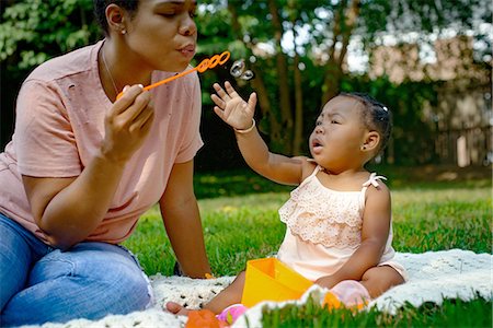simsearch:649-08578141,k - Mid adult woman blowing bubbles in garden for baby daughter Stock Photo - Premium Royalty-Free, Code: 614-09147728