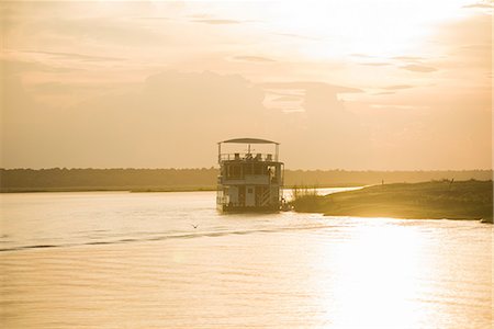 Boat on river at sunset, Chobe National Park, Botswana Stock Photo - Premium Royalty-Free, Code: 614-09159542