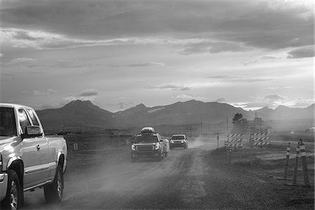 Pick-up and cars on dusty dirt track at dusk, B&W, Browning, Montana, USA Photographie de stock - Premium Libres de Droits, Code: 614-09159708