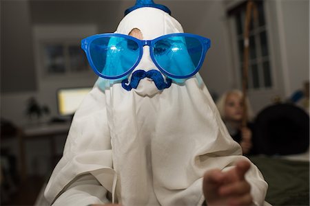 Girl dressed up as ghost with mustache and over sized sunglasses Stock Photo - Premium Royalty-Free, Code: 614-09159733