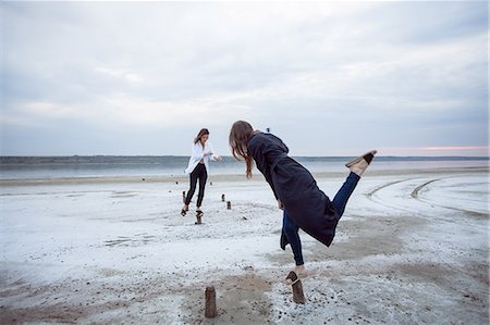 Women balancing on wooden stumps on beach, Odessa, Ukraine Stock Photo - Premium Royalty-Free, Code: 614-09168184