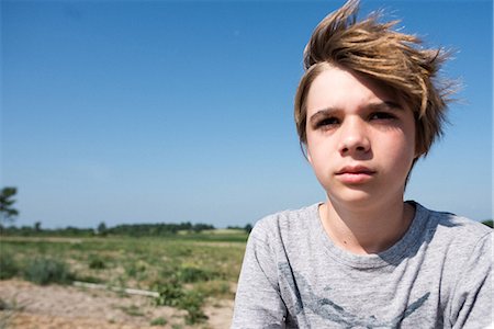 Teenage boy, flat countryside in background Foto de stock - Sin royalties Premium, Código: 614-09168247