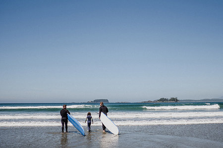 Friends with daughter surfing on beach, Tofino, Canada Stock Photo - Premium Royalty-Free, Code: 614-09178150