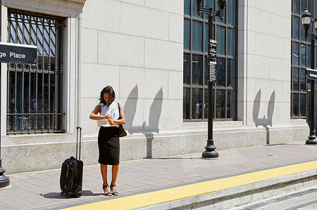 simsearch:614-09178221,k - Businesswoman checking time by light rail line Foto de stock - Royalty Free Premium, Número: 614-09178226