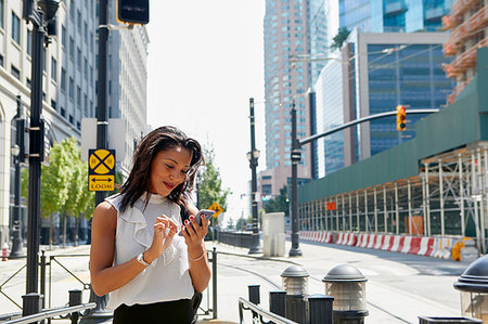 simsearch:614-09178221,k - Businesswoman using cellphone by barriers Foto de stock - Royalty Free Premium, Número: 614-09178235