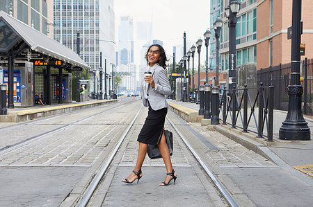 simsearch:614-09178221,k - Businesswoman crossing light rail tracks Foto de stock - Royalty Free Premium, Número: 614-09178272
