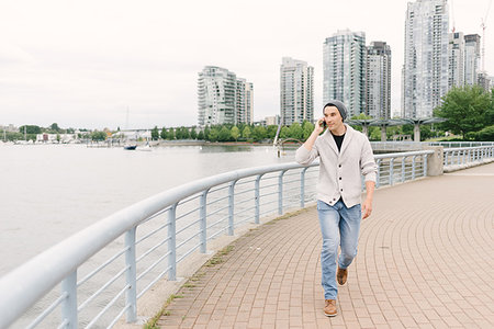 esplanade - Young man talking on phone while walking along seawall, Yaletown, Vancouver, Canada Stock Photo - Premium Royalty-Free, Code: 614-09178422