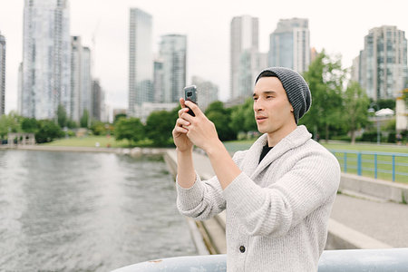 Young man taking photo on seawall, Yaletown, Vancouver, Canada Stock Photo - Premium Royalty-Free, Code: 614-09178423