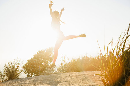 Woman jumping into air on hilltop Foto de stock - Sin royalties Premium, Código: 614-09178443