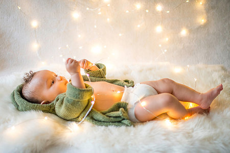 simsearch:614-08881045,k - Baby boy lying on furry rug playing with decorative lights Fotografie stock - Premium Royalty-Free, Codice: 614-09183049
