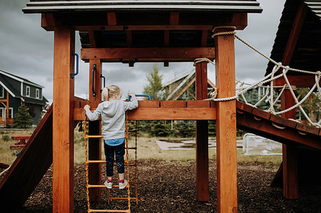 Girl climbing ladder to playground platform, rear view Stock Photo - Premium Royalty-Free, Code: 614-09183094