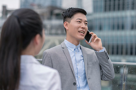 simsearch:614-09017557,k - Young businesswoman and man talking on smartphone in city, Shanghai, China Fotografie stock - Premium Royalty-Free, Codice: 614-09183096