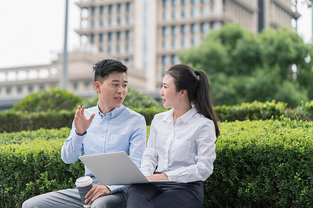 simsearch:614-09017526,k - Young businesswoman and man using laptop and chatting on city seat, Shanghai, China Fotografie stock - Premium Royalty-Free, Codice: 614-09183103