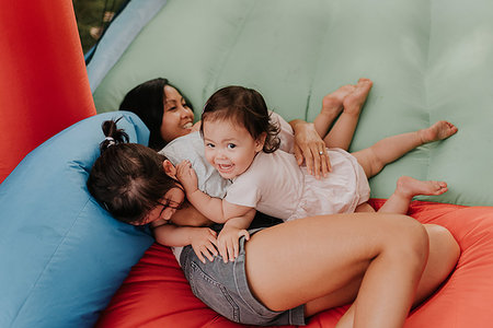 simsearch:614-09017444,k - Mother and daughters playing on bouncy castle Stock Photo - Premium Royalty-Free, Code: 614-09198275