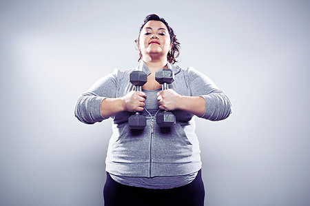 Mid adult woman using hand weights Stock Photo - Premium Royalty-Free, Code: 614-09209922