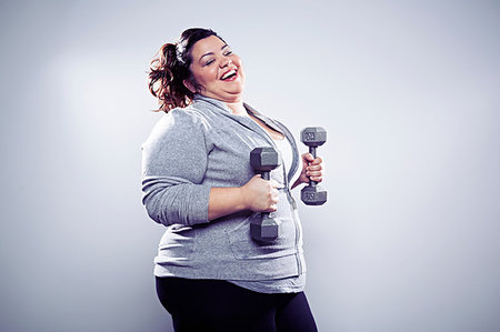 fat 30 year old - Mid adult woman using hand weights Stock Photo - Premium Royalty-Free, Code: 614-09209923