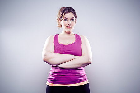 fat woman arms folded - Young woman wearing purple vest, arms crossed Stock Photo - Premium Royalty-Free, Code: 614-09209933