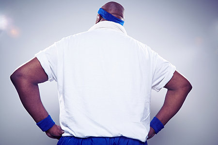 Mature man wearing white t shirt with hands on hips, rear view Stock Photo - Premium Royalty-Free, Code: 614-09209948
