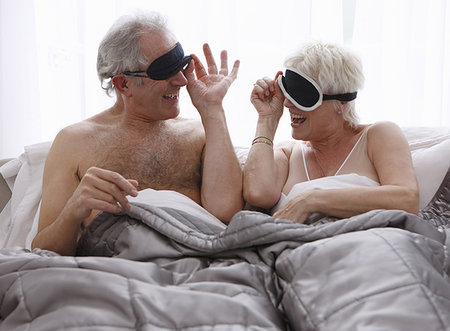 Senior couple removing face masks in bed Stock Photo - Premium Royalty-Free, Code: 614-09210009